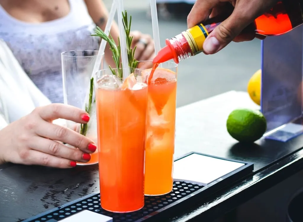 Un barman termine deux cocktails fruités sur le comptoir