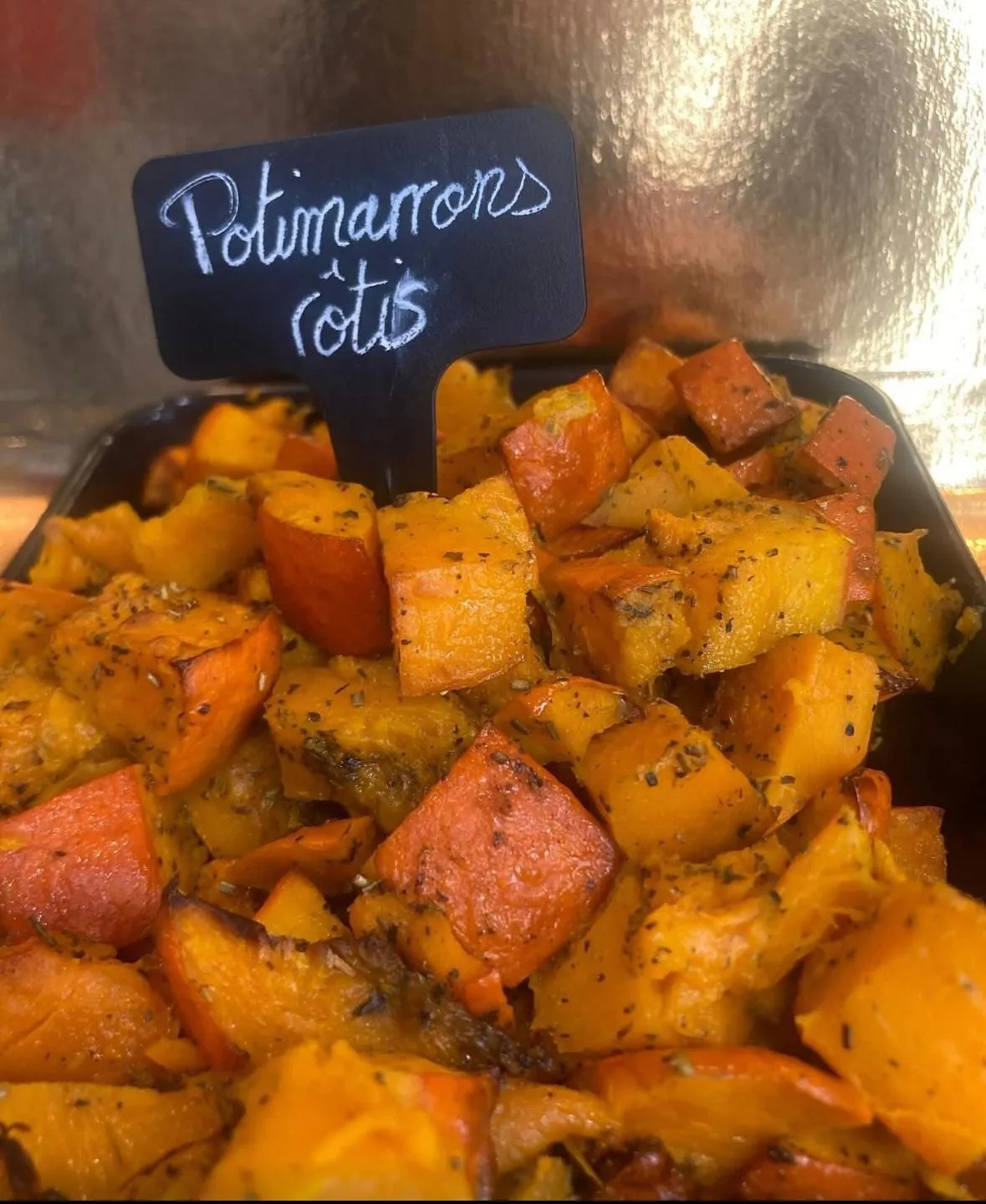 Potimarrons rôtis aux herbes dans leur barquette noire, avec l'ardoise « Potimarrons rôtis »