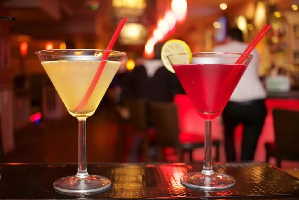 Deux cocktails colorés servis en verre à pied