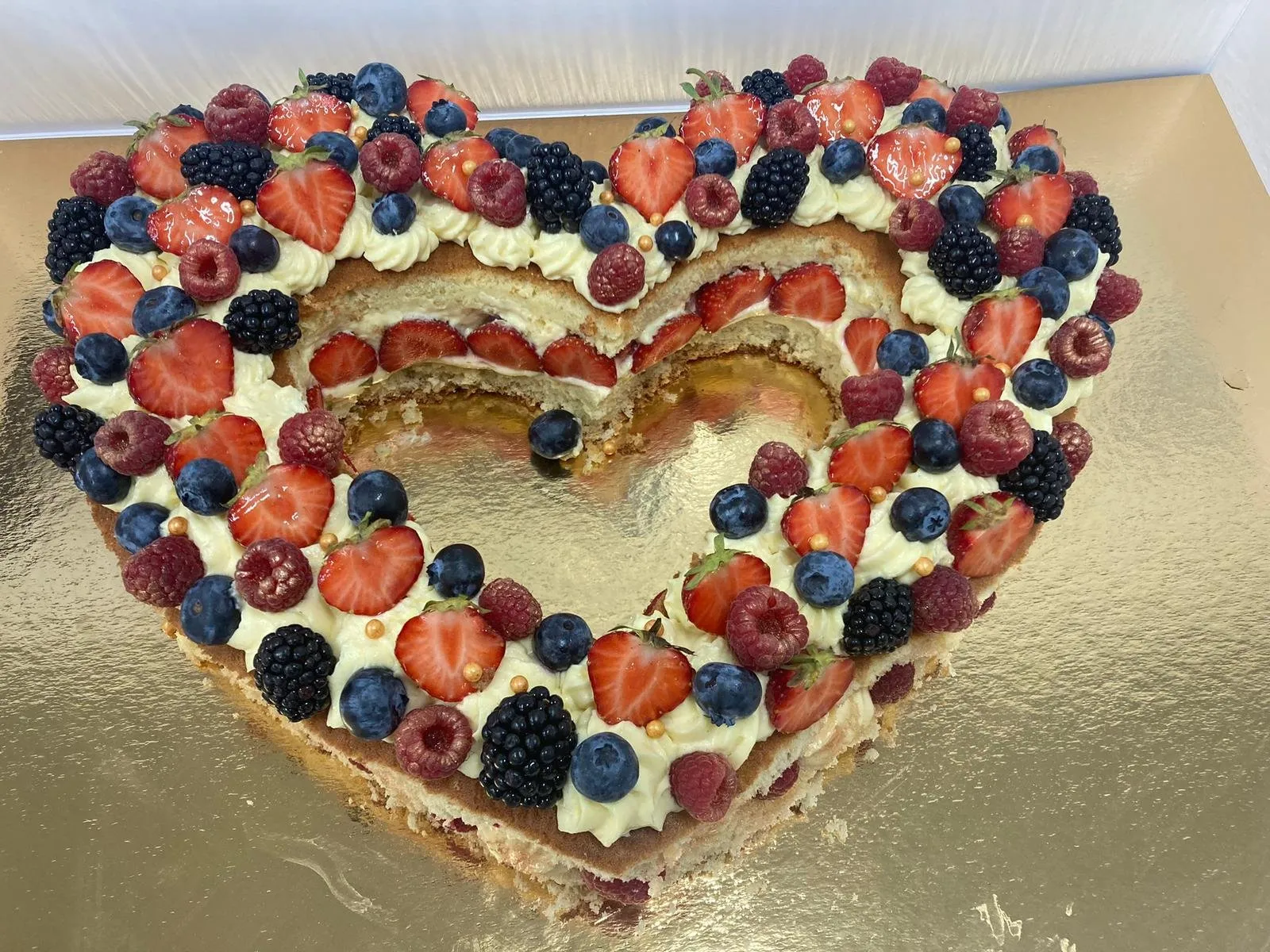 Gâteau en forme de cœur garni de fruits rouges