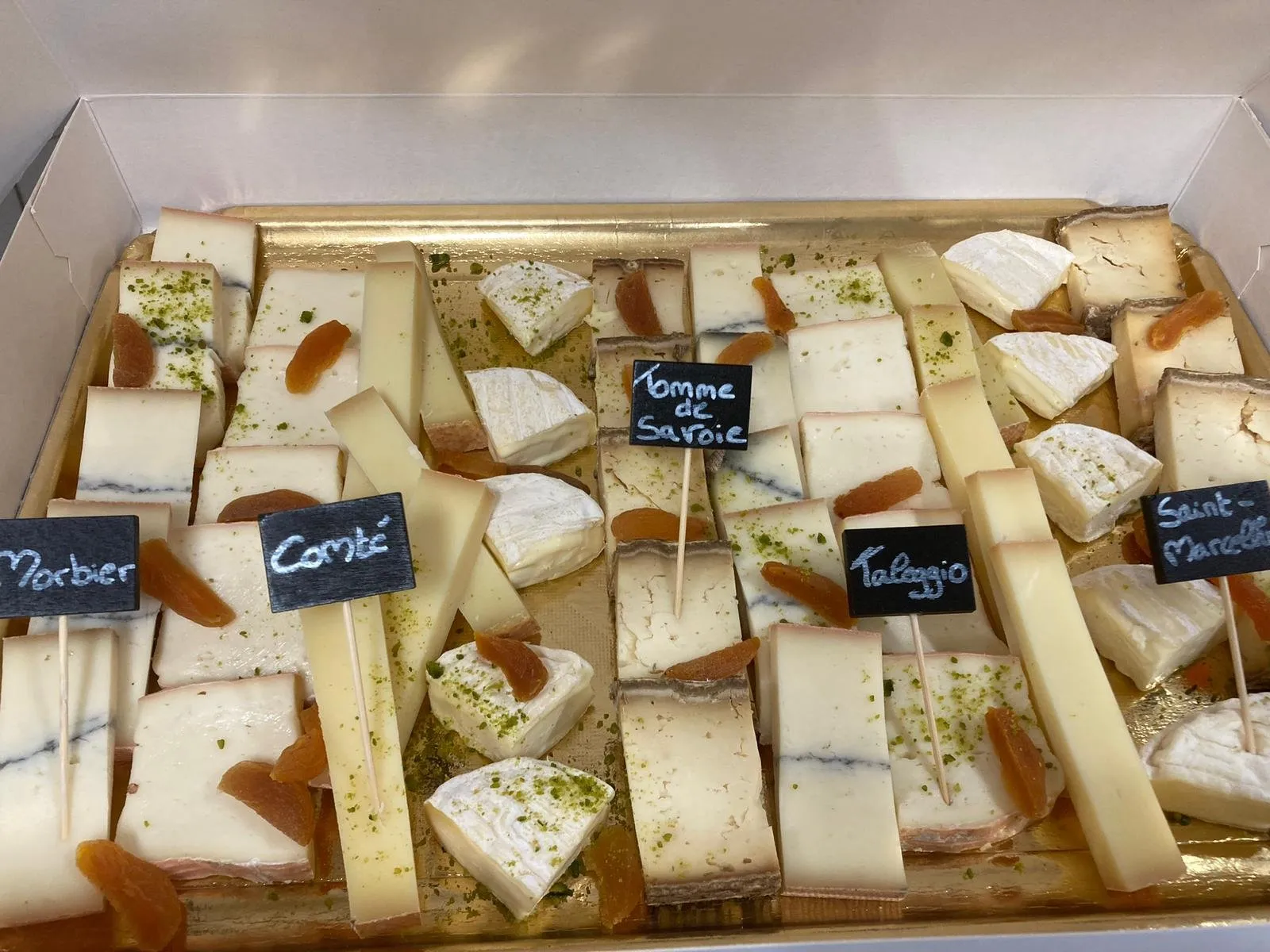 Plateau de fromages étiquetés : morbier, comté, tomme de Savoie, taleggio