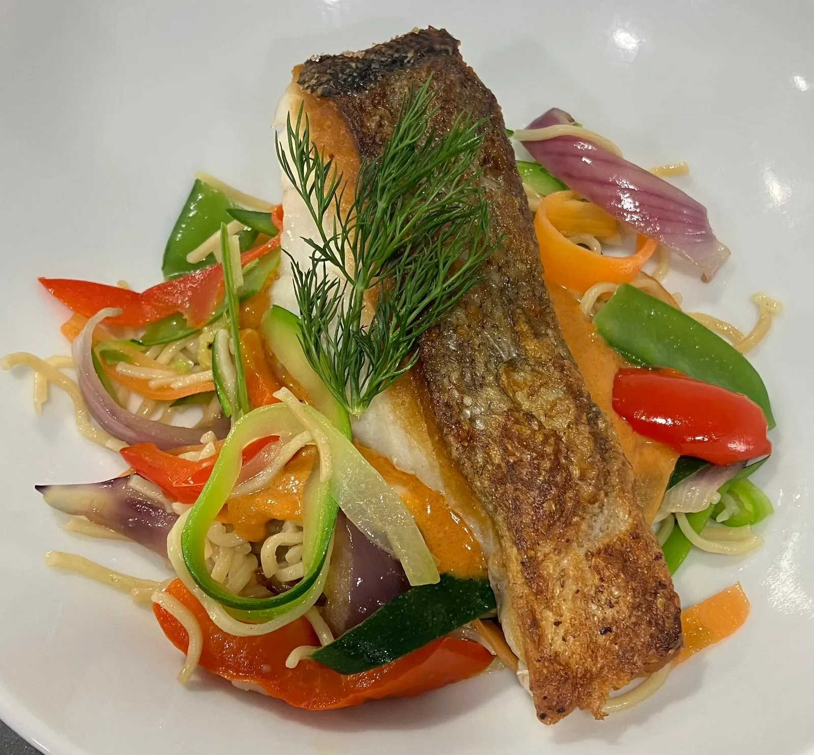 Dos de poisson rôti sur la peau, aneth, wok de légumes croquants et nouilles, sauce au poivron