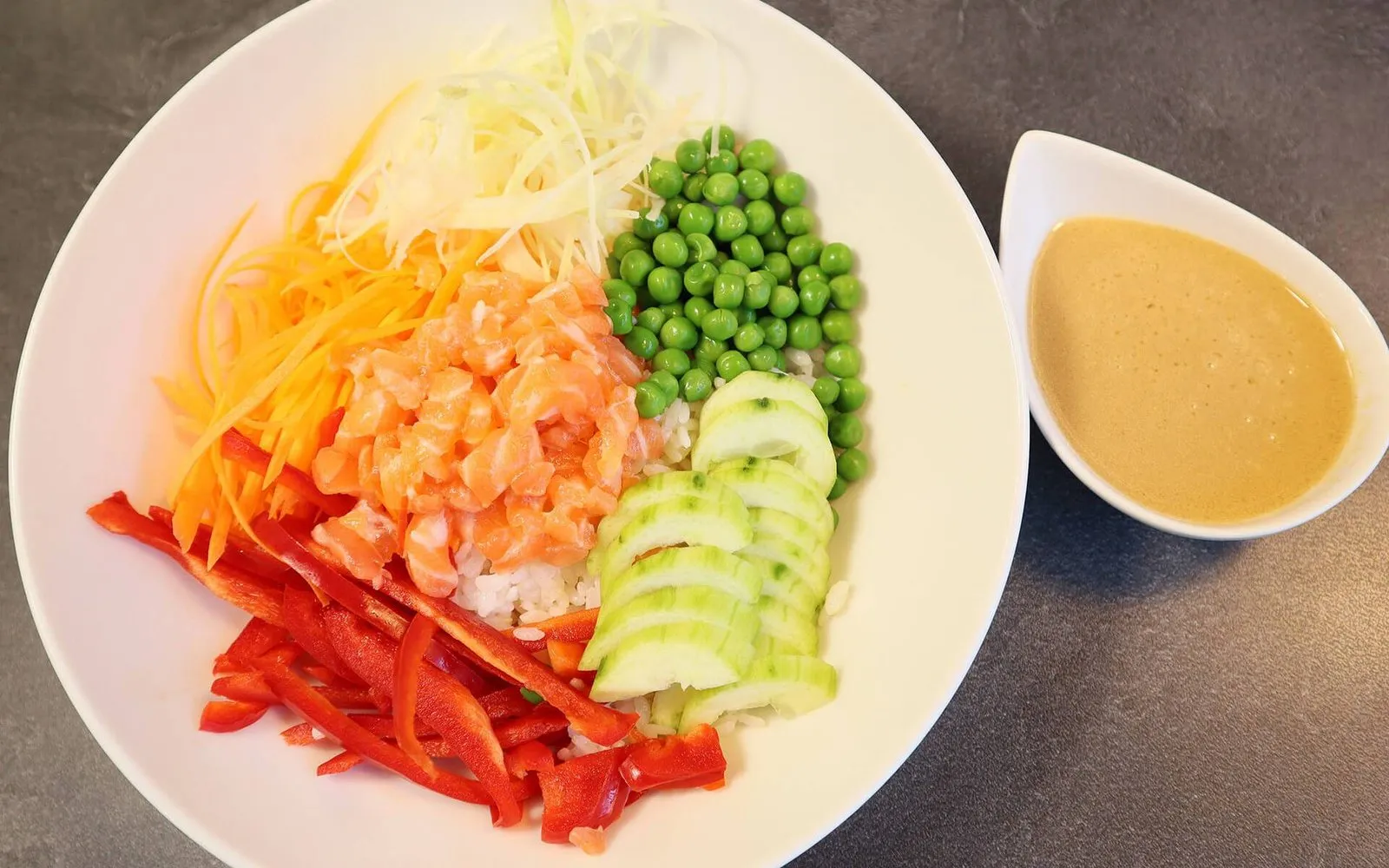 Poke bowl au saumon : saumon frais, petits pois, poivrons, concombre et sauce sésame