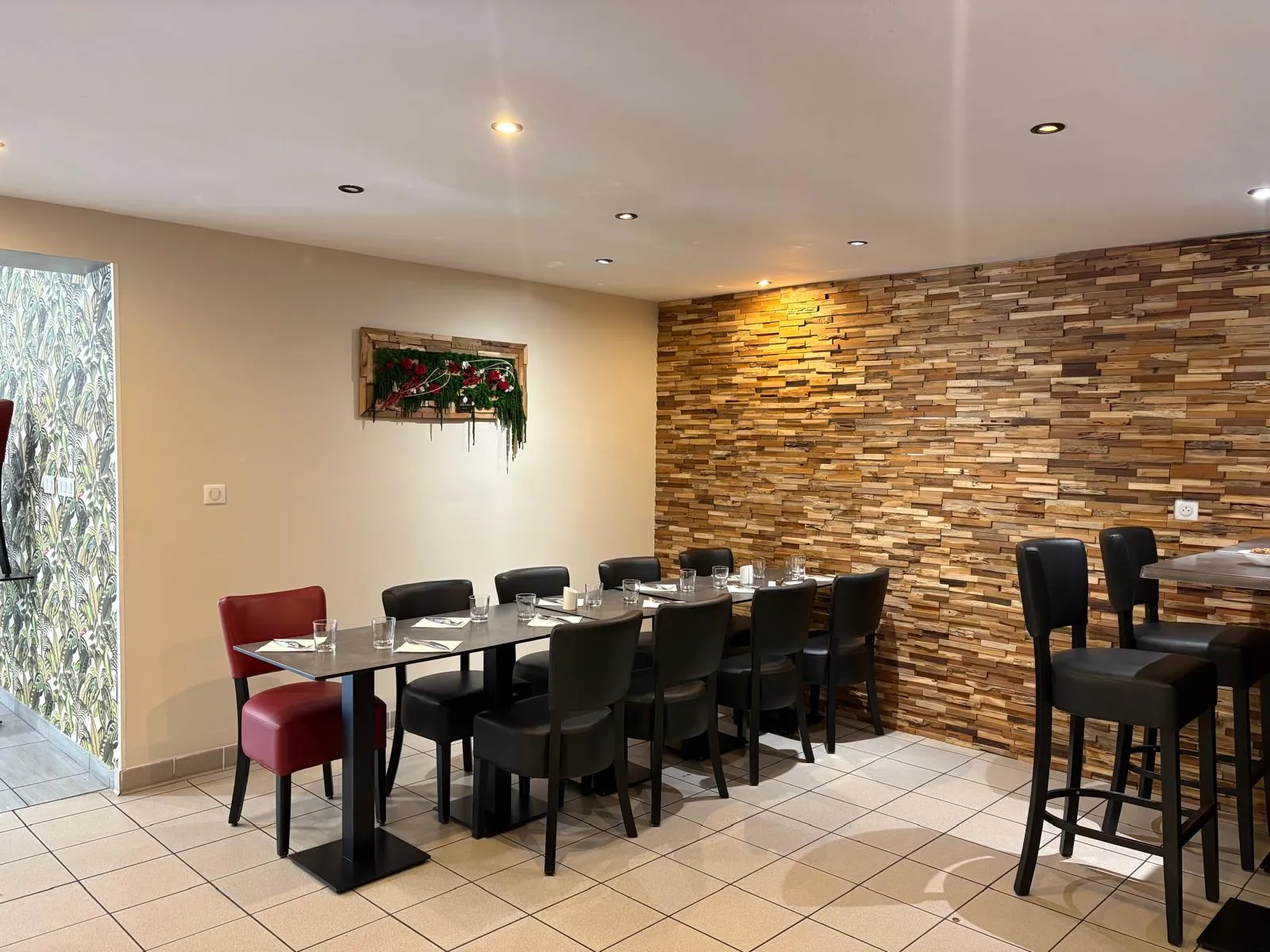 La salle du restaurant : mur de pierres de bois, tables dressées et mange-debout