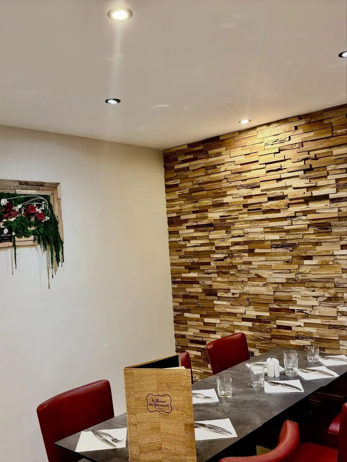 La salle : mur de bois, fauteuils de cuir rouge et carte posée sur la table