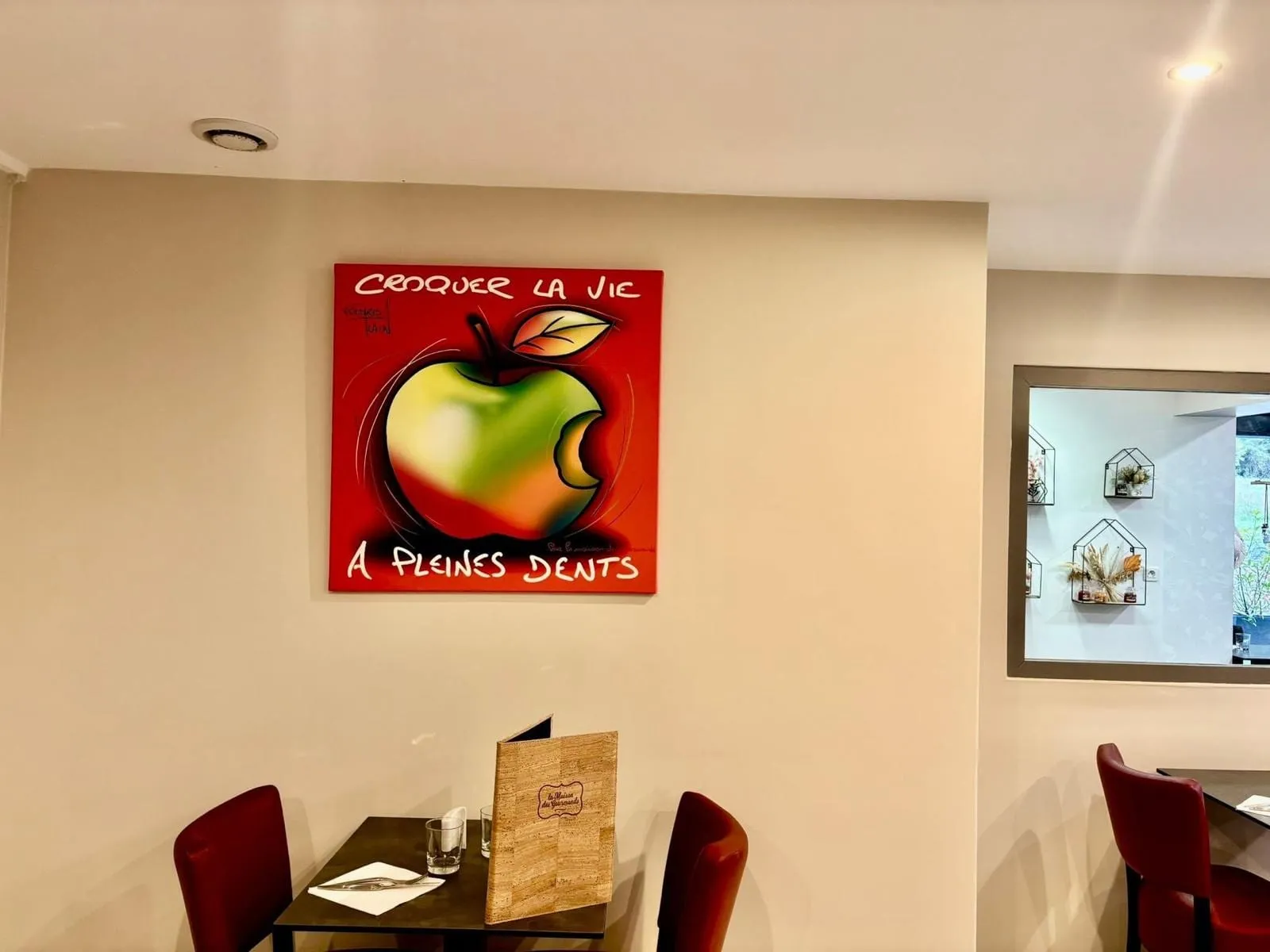 Le tableau « Croquer la vie à pleines dents » accroché dans la salle du restaurant