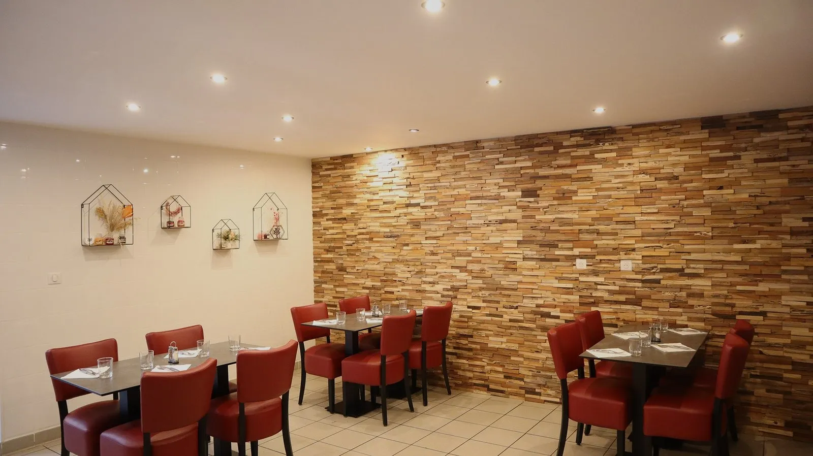 La salle du restaurant, mur en bois recyclé et fauteuils rouges