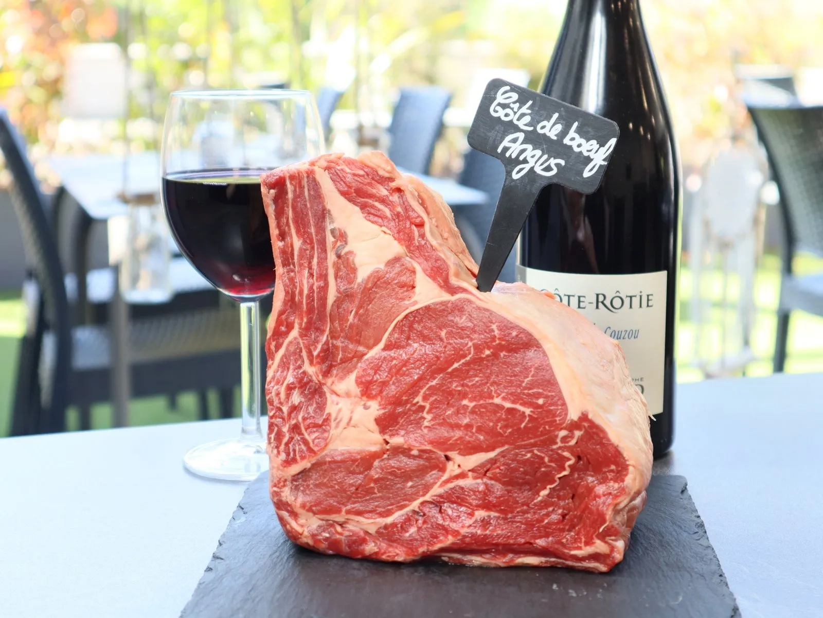 Un verre de Côte-Rôtie servi à table, à côté d'une pièce de bœuf